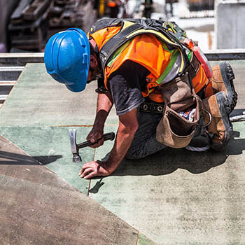 Roofer on the roof with hammer